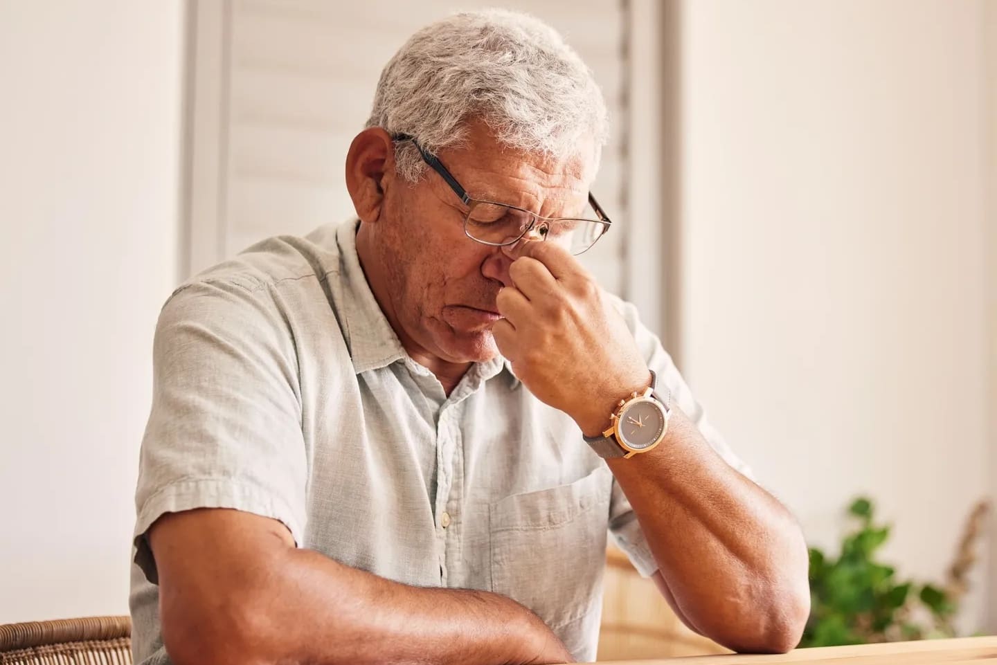 A man sitting at a table with his head down.