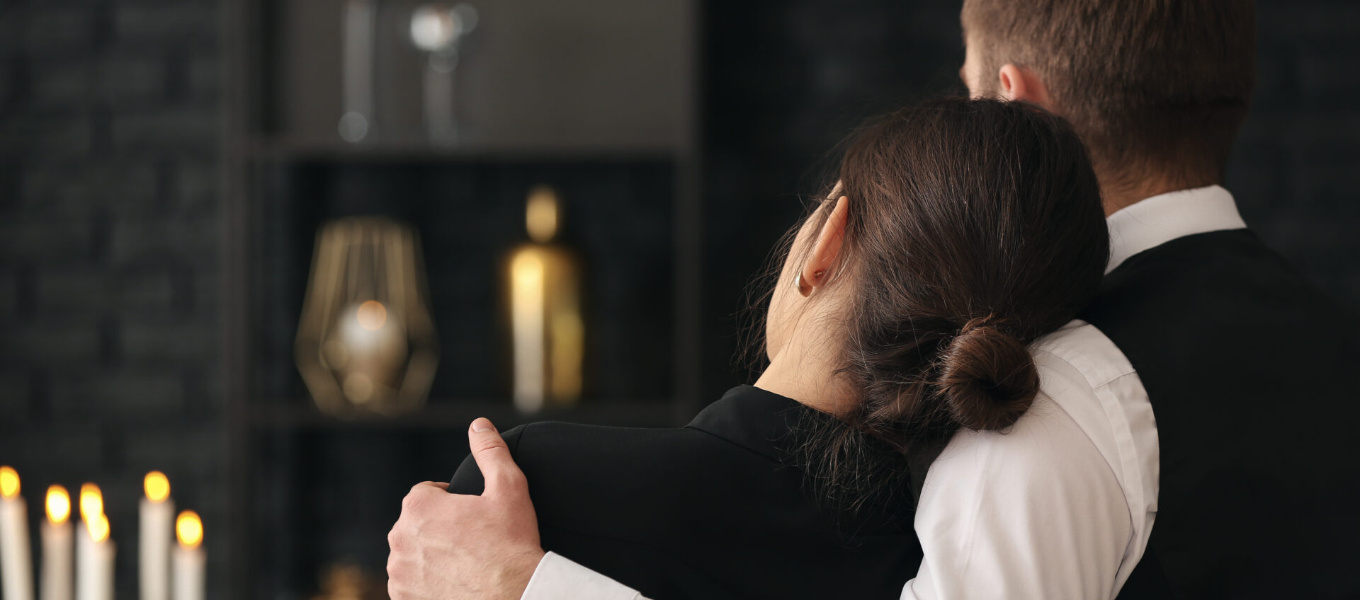 A woman in black jacket holding another person 's arm.